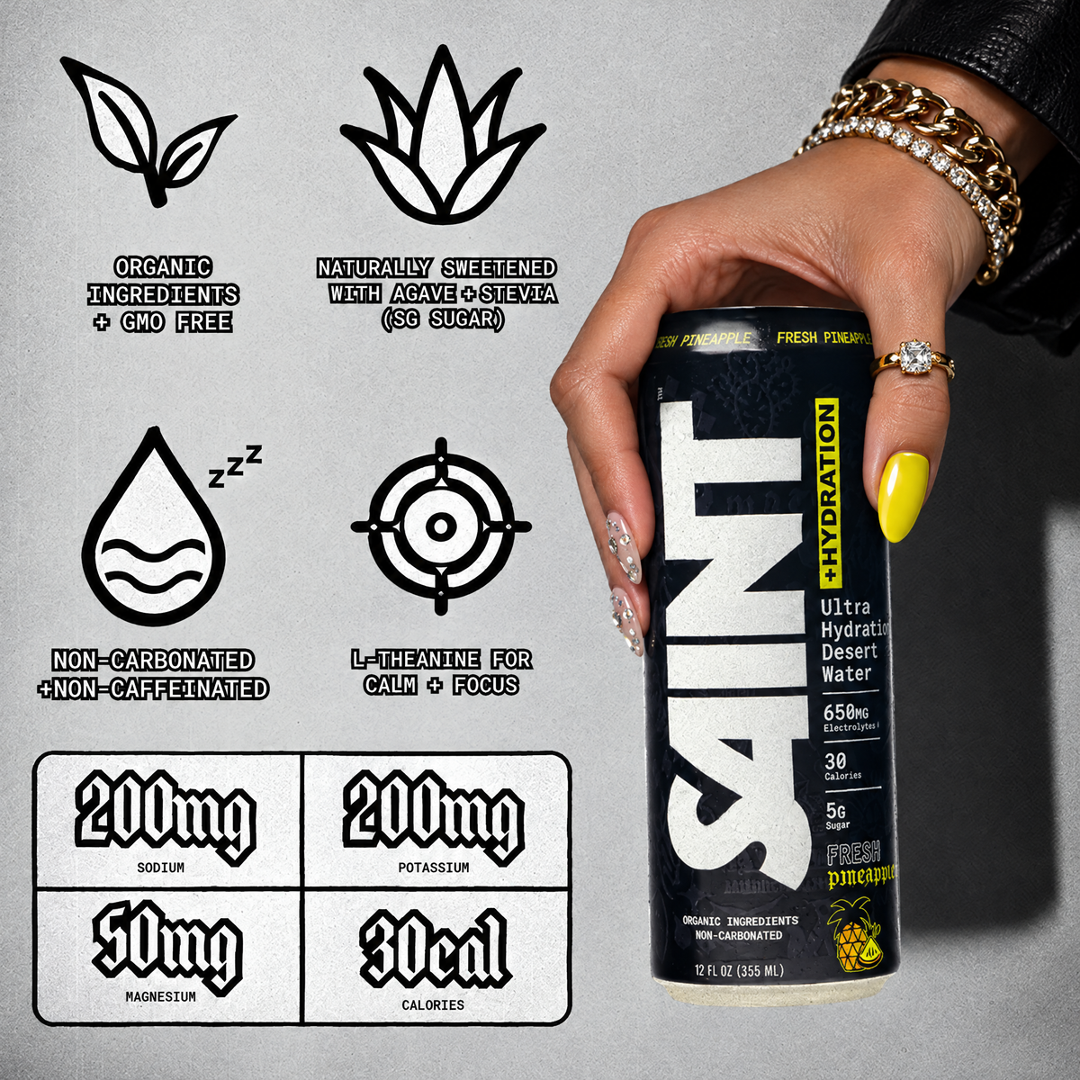 A hand wearing a gold chain bracelet and ring holds a can of SAINT hydration ultra hydrating desert water. The background is a textured light gray wall with black informational graphics detailing product features like organic ingredients, natural sweetness, non-carbonation, and caffeine-free content.